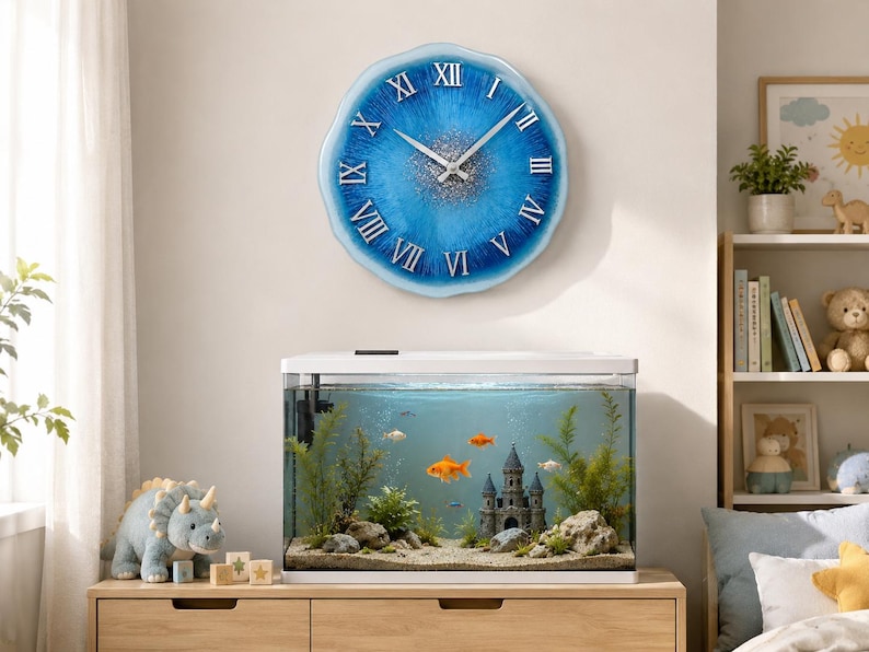 May include: A round wall clock with a scalloped edge, featuring a blue and white resin finish with silver glitter accents in the center. The clock face displays white Roman numerals and silver hands, mounted above a rectangular glass fish tank.