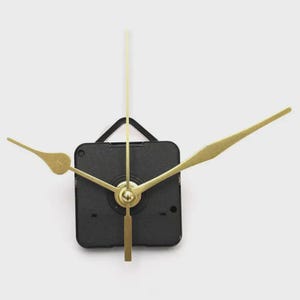 May include: A black clock movement with gold-colored hands and a gold-colored pendulum. The clock hands are shaped like arrows. The clock movement is square and has a black plastic casing. The clock hands are of different lengths.