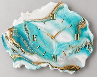 Può includere: Un orologio da parete di forma irregolare simile a un geode, caratterizzato da una miscela vorticosa di resina turchese, bianca e dorata. Il quadrante presenta numeri romani dorati alle ore dodici, tre, sei e nove, con lancette dorate.