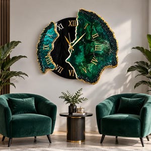 Puede incluir: Un gran reloj de pared con un centro circular negro con n&uacute;meros romanos dorados y dos paneles laterales irregulares inspirados en geodas, en color verde esmeralda profundo con bordes dorados y manecillas doradas.