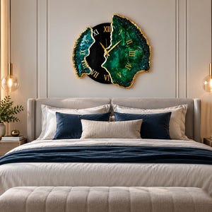 Puede incluir: Un reloj de pared con un centro circular negro, n&uacute;meros romanos dorados y manecillas doradas, flanqueado por dos piezas irregulares inspiradas en geodas de color verde esmeralda con bordes texturizados y dorados.