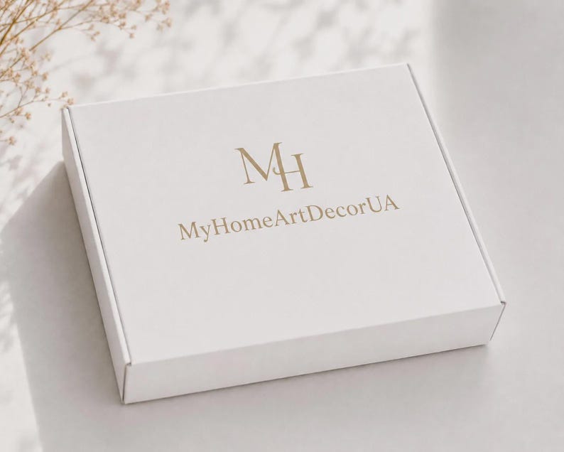 May include: A square white cardboard shipping box featuring the gold-colored logo MH and the text MyHomeArtDecorUA printed on the top surface. The box is closed and has a clean, matte finish with sharp edges and a standard folding design.