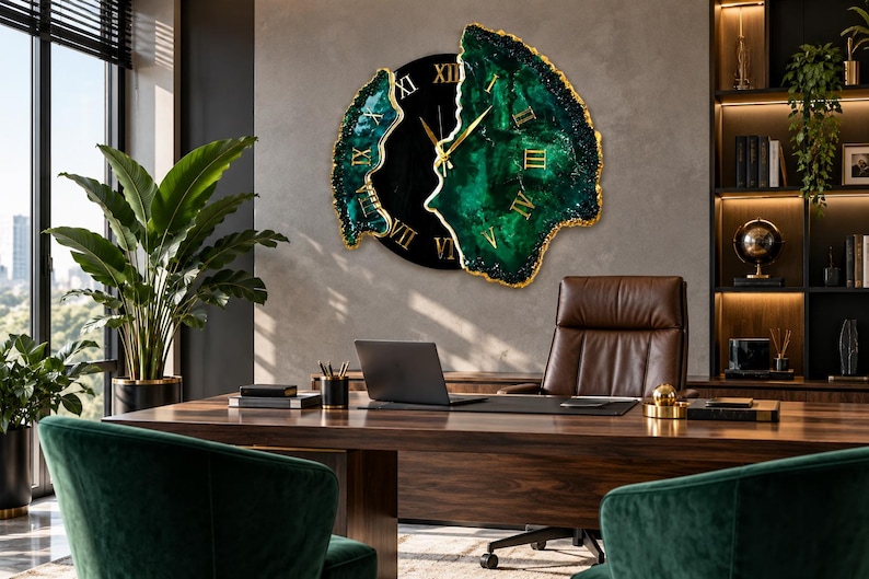 Puede incluir: Un reloj de pared con un centro circular negro con n&uacute;meros romanos dorados y dos paneles laterales irregulares inspirados en geodas en verde esmeralda profundo con bordes dorados. El reloj tiene manecillas doradas finas y est&aacute; en una pared.