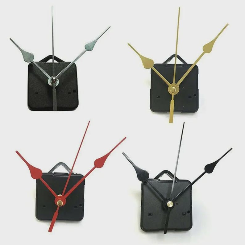 May include: Four clock movements with different colored hands. The clock movements have black square bodies with a small handle at the top. The hands are silver, gold, red, and black.