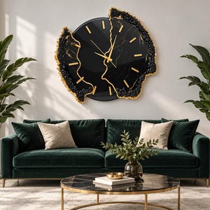 Pu&ograve; includere: Un grande orologio da parete circolare con quadrante nero, lancette e indici dorati. L'orologio presenta un design diviso con bordi irregolari e testurizzati in nero e oro che ricordano formazioni di pietra o cristallo.