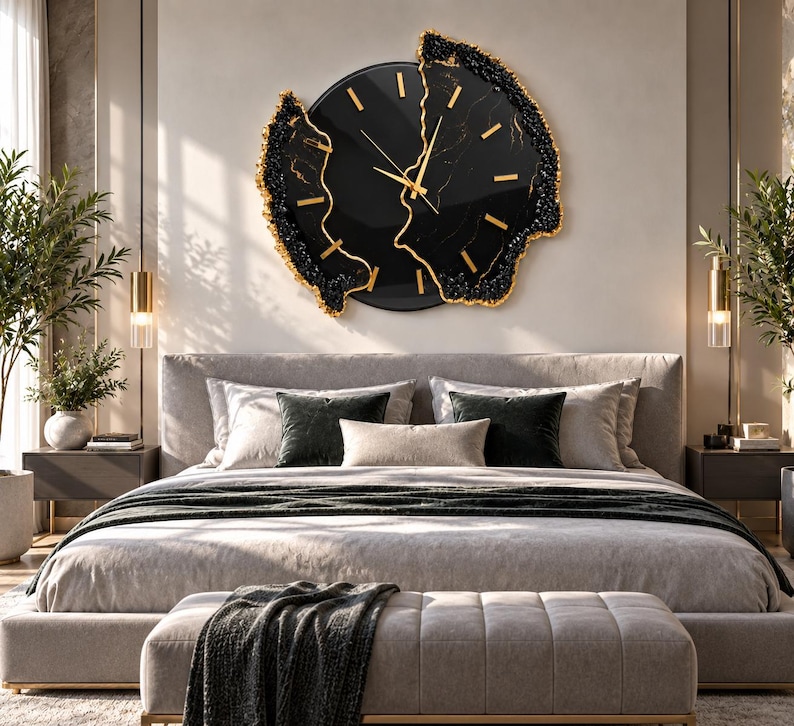 Pu&ograve; includere: Un grande orologio da parete circolare con quadrante nero lucido, indici e lancette color oro. L'orologio presenta un bordo irregolare e testurizzato in nero e oro che ricorda l'aspetto della pietra naturale o delle formazioni geodiche.