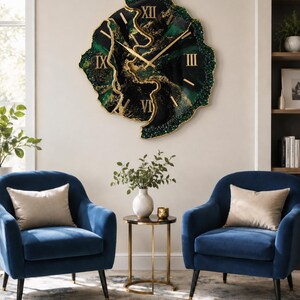 May include: A large, irregular, geode-style wall clock featuring a deep black and emerald green resin surface with gold-colored veins and accents. The clock face displays gold Roman numerals and thin gold hands, with a textured, crystalline edge.