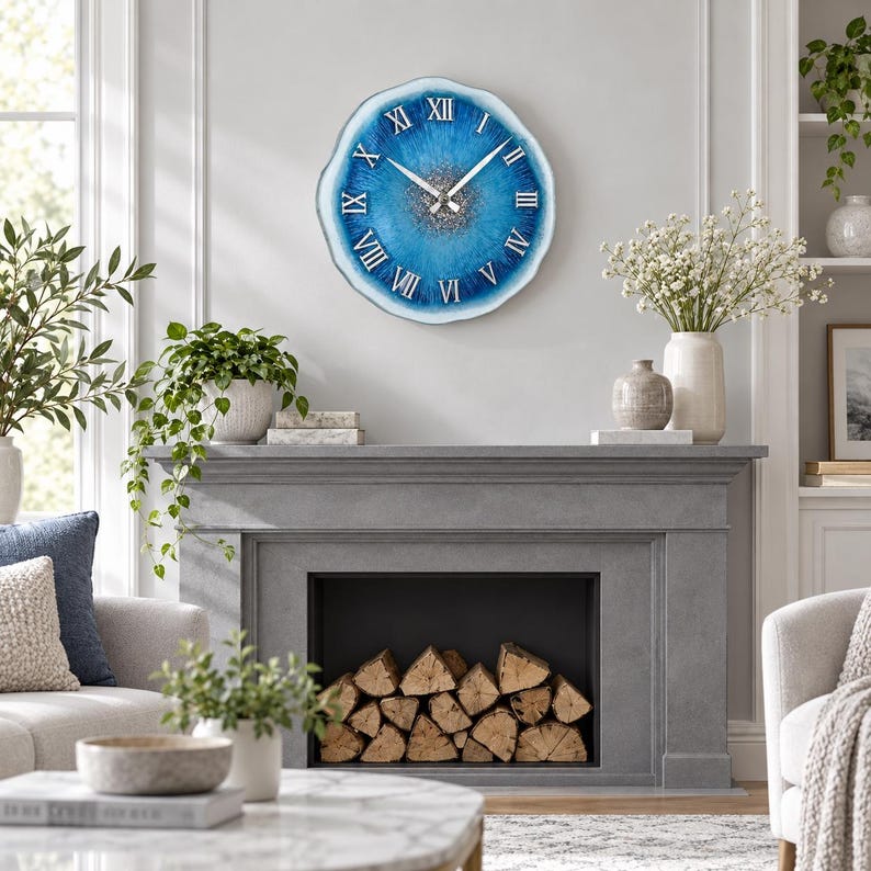 May include: A round wall clock with a blue and white agate-inspired resin face, featuring silver Roman numerals and silver hands. The center of the clock has a textured, sparkling silver finish, and the outer edge has a white, wavy border.