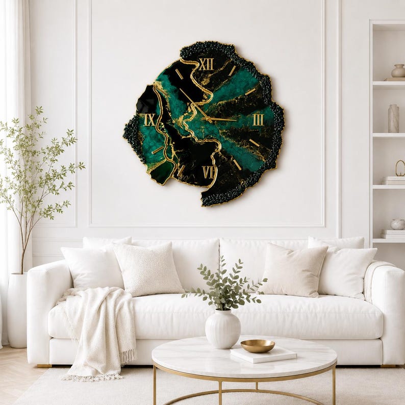 May include: A large, irregular, geode-style wall clock featuring a deep emerald green and black resin surface with gold-colored veins and gold Roman numerals. The clock has a textured, dark, rocky border and gold hands, creating a bold focal point.