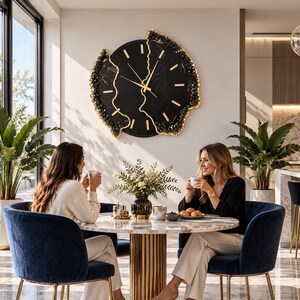 Pu&ograve; includere: Un grande orologio da parete circolare con quadrante nero, indici e lancette color oro. L'orologio presenta un design dai bordi irregolari e frastagliati, accentuato da un materiale cristallino scuro e testurizzato con finiture dorate.