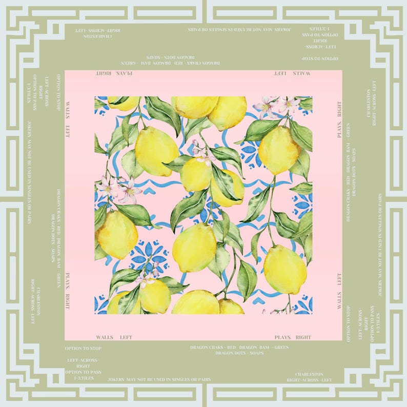 May include: A square, decorative fabric with a lemon and floral pattern on a pink background. The lemons are yellow with green leaves and blue accents. The fabric is framed by a light green border with text.