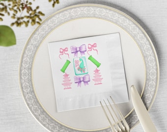 May include: A white paper napkin with a watercolour design featuring pink and purple bows, green bamboo, and pink pagodas. A teal and green image with text is in the centre. The napkin is on a white plate with a silver rim, with a fork and knife.