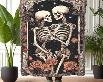 May include: A tapestry throw blanket with a dark background featuring two skeletons embracing, surrounded by roses and stars. The skeletons are depicted in a romantic pose, with the female skeleton holding the male skeleton's hand.