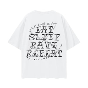 Puede incluir: Camiseta blanca con un estampado gráfico negro que dice "Eat Sleep Rave Repeat" en una fuente estilizada.