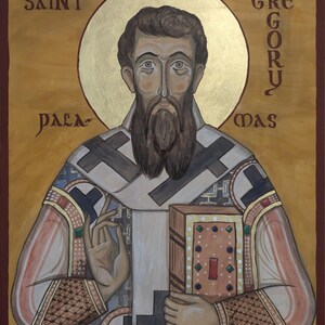 Op de afbeelding: Een icoon van Sint Gregorius Palamas, met een gouden aureool en tekst. De figuur heeft een lange bruine baard en houdt een boek vast. Het kunstwerk is geschilderd met een warm kleurenpalet, waaronder goud, bruin en rode accenten, en is omlijst door een donkerbruine rand.