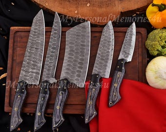 May include: A set of six Damascus steel kitchen knives with dark wood handles and brass rivets. The blades have a unique pattern. The knives are displayed on a wooden cutting board with vegetables in the background. The text "MyPersonalMemories4u" is visible.