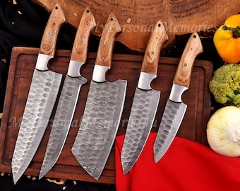 May include: A set of six kitchen knives with wooden handles and textured blades. The blades have a unique pattern and are made of stainless steel. The knives are arranged on a wooden cutting board, with a red cloth in the foreground.