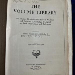 May include: The cover of a book titled "The Volume Library: A Concise, Graded Repository of Practical and Cultural Knowledge Designed for both Instruction and Reference". The book is illustrated with a drawing of an open book and the text "Profusely Illustrated". The book was published by Educators Association, 307 Fifth Ave., New York, N.Y.