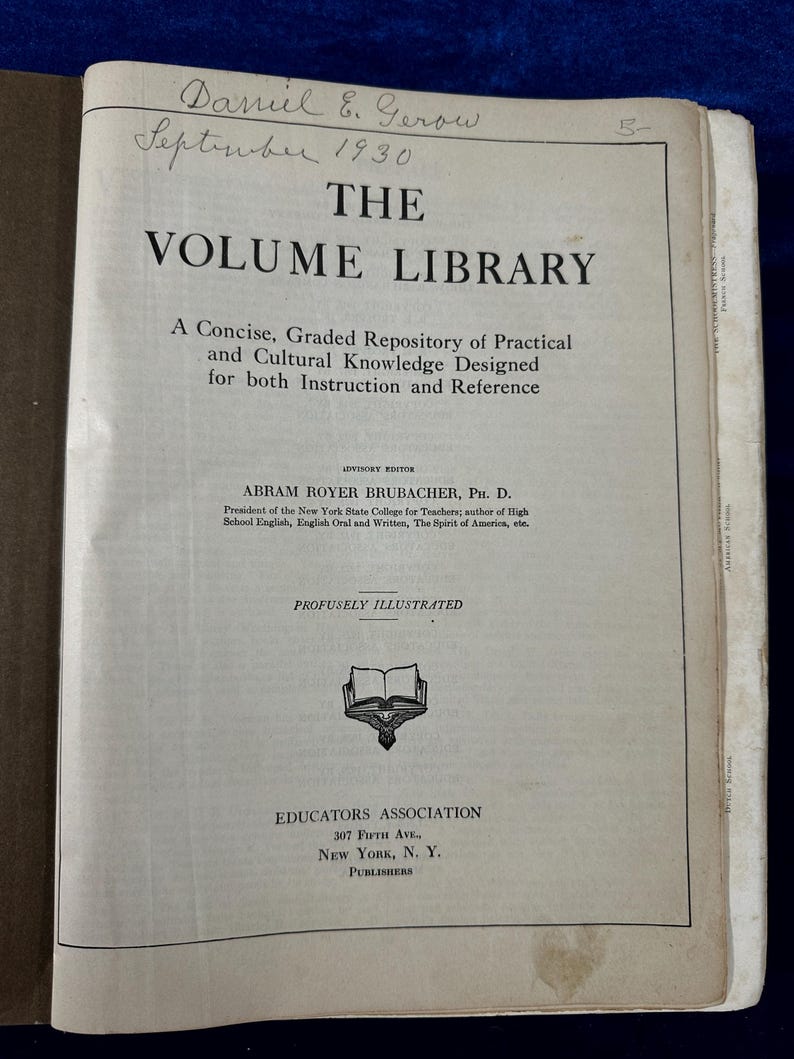 May include: The cover of a book titled "The Volume Library: A Concise, Graded Repository of Practical and Cultural Knowledge Designed for both Instruction and Reference". The book is illustrated with a drawing of an open book and the text "Profusely Illustrated". The book was published by Educators Association, 307 Fifth Ave., New York, N.Y.
