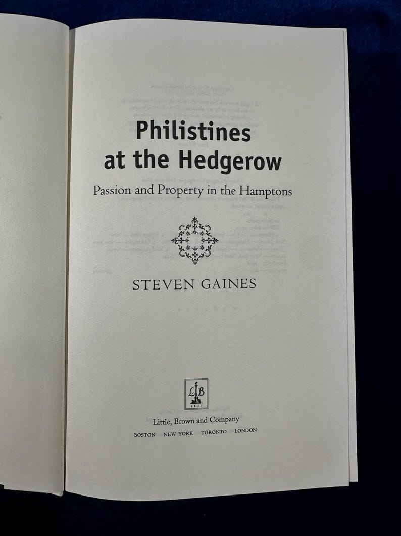 May include: A book cover with the title "Philistines at the Hedgerow: Passion and Property in the Hamptons" by Steven Gaines. The cover is white with black text and a decorative design.