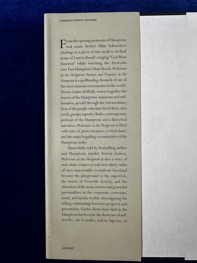 May include: A book cover with a white background and black text. The title of the book is "Philistines at the Hedgerow: Passion and Property in the Hamptons". The text on the cover describes the book as a "spellbinding chronicle" of the Hamptons, a community known for its mansions and millionaires.