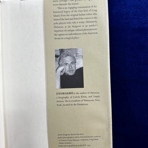 May include: A book cover with a photo of a man with a beard and glasses. The book title is "Philistines at the Hedgerow" and the author is Steven Gaines. The back cover text describes the book as an engaging examination of the historical legacy of the East End of Long Island.