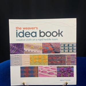 May include: The Weaver's Idea Book: Creative Cloth on a Rigid Heddle Loom by Jane Patrick. The book cover features a white background with colorful woven fabric samples.