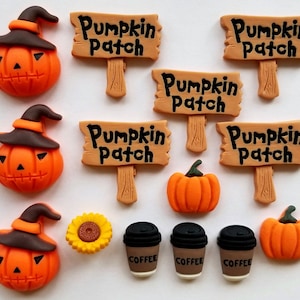 May include: An assortment of Halloween-themed decorations, including pumpkin patch signs, jack-o'-lantern ornaments, a sunflower, and coffee cups.
