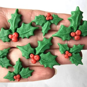 May include: Green holly leaves with red berries. These decorative holly sprigs are ideal for festive crafts and decorations. Each sprig features detailed leaf textures and vibrant colours, perfect for adding a festive touch to any project.