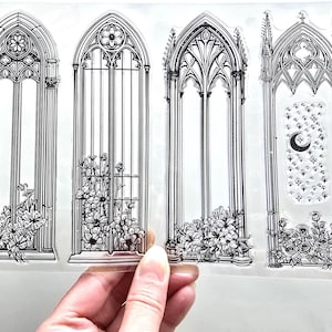May include: Clear stamp set showing four gothic arch window designs with floral details. The windows have detailed architectural features, including a design with a crescent moon and stars.