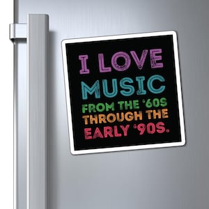 May include: A square magnet with the text "I LOVE MUSIC FROM THE '60S THROUGH THE EARLY '90S." The text is in various colours, including purple, blue, orange, and pink, on a black background. The magnet is on a silver refrigerator.