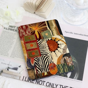 May include: A rectangular e-reader cover featuring a vibrant collage of patterns including a zebra stripe section, a sunburst motif, green rectangular panels with orange centers, and abstract shapes in shades of red, gold, black, and green.