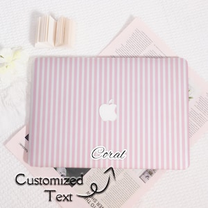 May include: A pink and white striped laptop case with the Apple logo. The case has the word "Coral" and the text "Customized Text" on it. The case is on top of a pink newspaper.