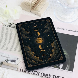 Pode incluir: Um leitor de e-book retangular com moldura preta e um ecrã que mostra uma sequência vertical de fases lunares douradas contra um céu noturno estrelado com nuvens, emoldurado por uma borda dourada com detalhes decorativos.