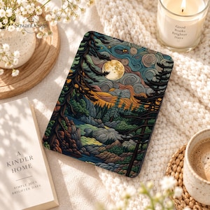 May include: A rectangular e-reader cover featuring a detailed illustration of a forest landscape at night under a full moon. The artwork displays swirling clouds, dark pine trees, and rocky terrain in shades of blue, green, and orange.