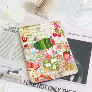 May include: A vibrant tablet case with a patchwork design, showcasing a cartoon caterpillar, strawberries, flowers, and a star. The case includes the text "I LIKE NOT ONLY THE" and "VISIT T FLOWER".