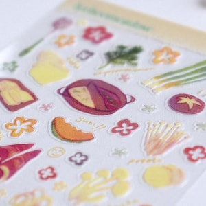 May include: A sheet of clear stickers with colourful illustrations of hot pot ingredients, including vegetables, meat, and tofu. The stickers are labelled "hotpot" and "yum!"