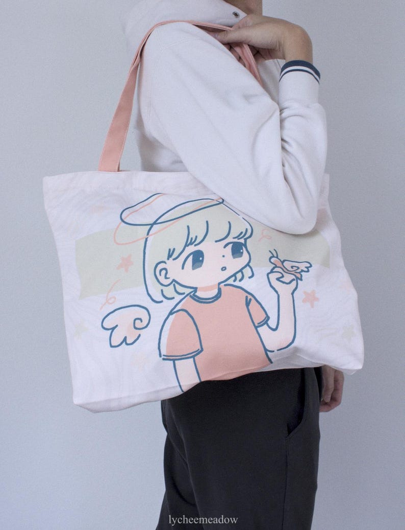 May include: A white canvas tote bag with a pink handle. The bag features a cartoon illustration of a girl with blonde hair and a halo, wearing a pink shirt and holding a butterfly. The text "lycheemeadow" is printed on the bottom of the bag.