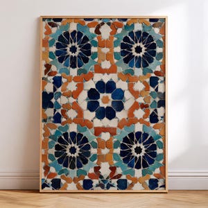May include: A framed print featuring a mosaic tile design. The artwork showcases a repeating pattern of geometric shapes in shades of blue, orange, and white. The frame is made of light-colored wood, adding a natural touch to the piece.