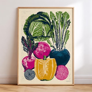 May include: A framed art print featuring a colorful still life of vegetables. The print showcases a cabbage, beets, a bell pepper, and other root vegetables in shades of green, yellow, pink, and blue. The artwork has a textured, linocut style.