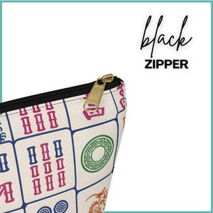 May include: A cream-coloured zippered pouch with a black zip and gold-coloured zip pull. The pouch is patterned with colourful Mahjong tiles in red, blue, green, and orange. The text "black ZIPPER" is written in black script.
