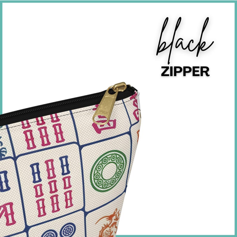 May include: A cream-coloured zippered pouch with a black zip and gold-coloured zip pull. The pouch is patterned with colourful Mahjong tiles in red, blue, green, and orange. The text "black ZIPPER" is written in black script.