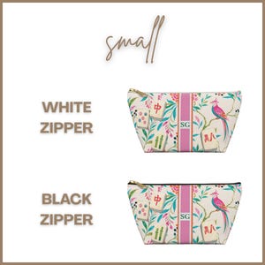 May include: Two small zippered pouches featuring a white background with a colorful pattern of mahjong tiles, tropical leaves, and a pink bird. A vertical pink stripe in the center displays the initials SG. One pouch has a white zipper, one black.