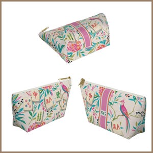 May include: Three zippered pouches featuring a cream background with a colorful pattern of mahjong tiles, pink birds, and green foliage. A vertical pink stripe on the pouches displays the letters SG in a white font, with gold-toned metal zippers.