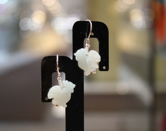 May include: A pair of silver dangle earrings with white jade rooster charms.
