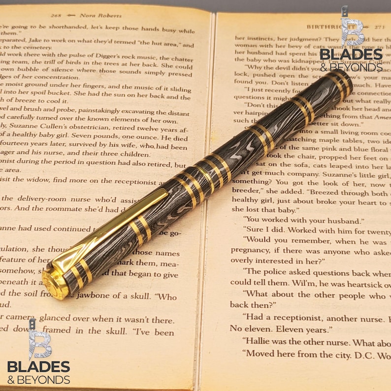 May include: A luxury fountain pen with a black and silver patterned barrel and gold-colored accents. The pen is lying on an open book with text. The pen is a writing instrument.