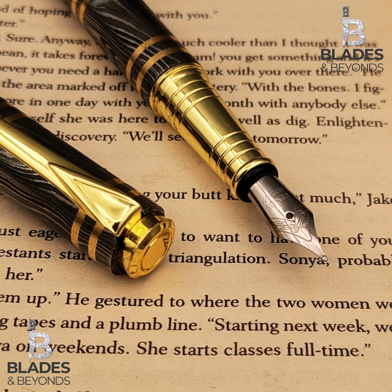 May include: Close-up of a black and gold fountain pen with intricate detailing. The pen features a patterned barrel and gold accents. The nib is visible, resting on a page of printed text. The pen is a writing instrument.