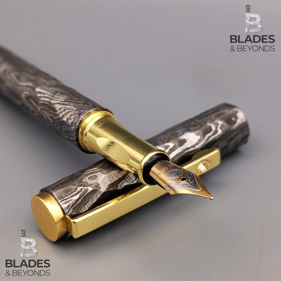 501 people favorited this hammered Damascus fountain pen — the wavy forge-pattern barrel is so visually striking it's basically wearable sculpture you write with.