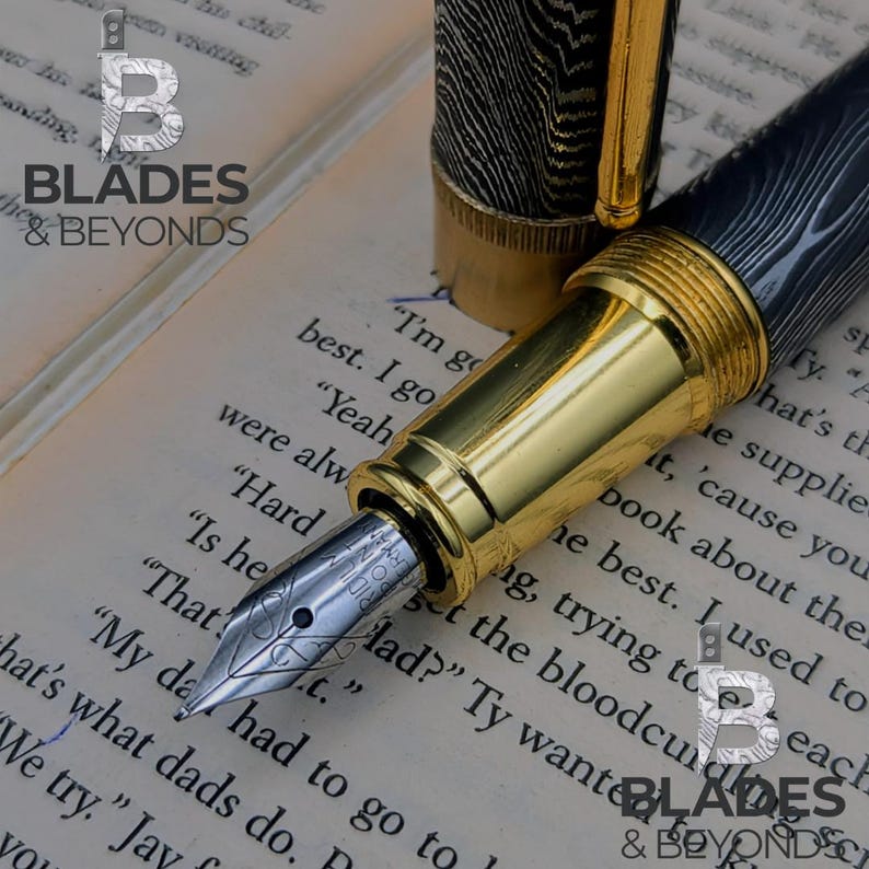 May include: A close-up of a luxury fountain pen with a gold-colored barrel and nib. The pen's cap and barrel feature a black and silver woodgrain pattern. The pen is resting on a book with printed text. The logo "BLADES & BEYONDS" is visible.