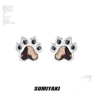 May include: A pair of silver-colored paw print stud earrings. Each earring features a paw print design with a brown and black center and black accents. The word "SUMIYAKI" is printed in black at the bottom.